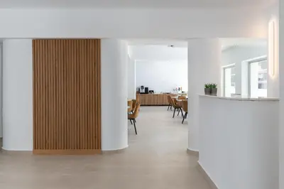 a hallway with white walls and a wooden partition at Rodos White in Rhodes Town
