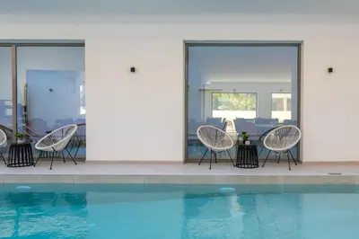 a group of chairs sitting next to a swimming pool at Rodos White in Rhodes Town