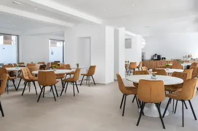 a dining room with white tables and chairs at Rodos White in Rhodes Town