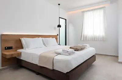 a bedroom with a large bed with white sheets at Rodos White in Rhodes Town
