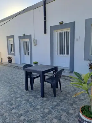 a table and a chair next to a table and a building at House of Happiness in Kritinía
