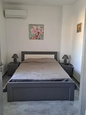 a bedroom with a bed with two nightstands and two lamps at House of Happiness in Kritinía