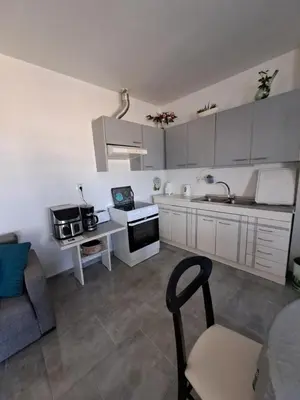 a kitchen with white cabinets and a table and a couch at House of Happiness in Kritinía