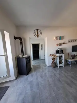 a living room with a fireplace and a tile floor at House of Happiness in Kritinía