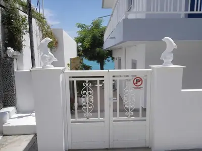 a white fence with a gate with se pigeons on it at Villa Amalia in Vrachonisída touArchangélou