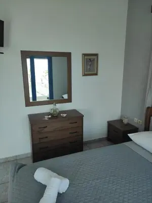 a bedroom with a bed with a mirror and a dresser at Villa Amalia in Vrachonisída touArchangélou