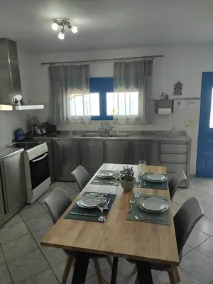 a kitchen with a wooden table with chairs and a tableablish at Villa Amalia in Vrachonisída touArchangélou