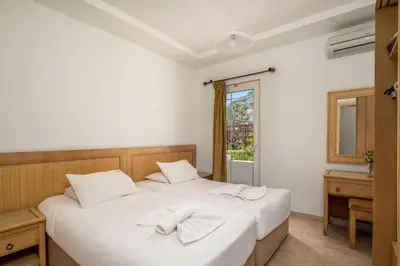 a bedroom with two beds with towels on them at Evi Studios & Apartments Pefkos in Pefki Rhodes