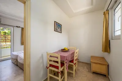 a small table and chairs in a room with a window at Evi Studios & Apartments Pefkos in Pefki Rhodes