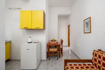 a kitchen with a table and a yellow cabinet at Evi Studios & Apartments Pefkos in Pefki Rhodes