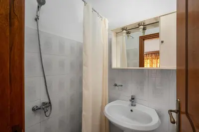 a bathroom with a sink and a toilet and a mirror at Evi Studios & Apartments Pefkos in Pefki Rhodes