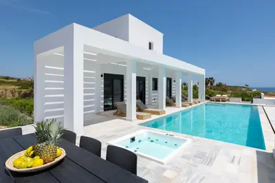 a villa with a swimming pool and a table with a bowl of fruit at Seashell Villa - Luxury Pool Retreat - 150m Beach in Lachania
