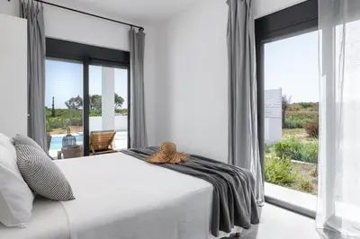 a bedroom with a white bed and a large window at Seashell Villa - Luxury Pool Retreat - 150m Beach in Lachania