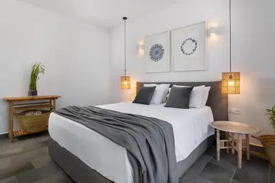 a bedroom with a large white bed and a table at Seashell Villa - Luxury Pool Retreat - 150m Beach in Lachania