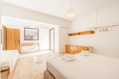 a white bedroom with two beds and a window at Rhodes Retreat in Kalithies
