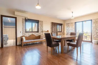 a dining room with a table and chairs and a couch at Rhodes Retreat in Kalithies
