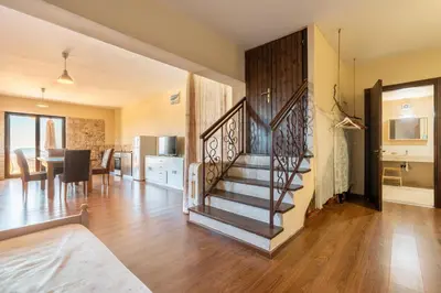 a living room with a staircase and a dining room at Rhodes Retreat in Kalithies