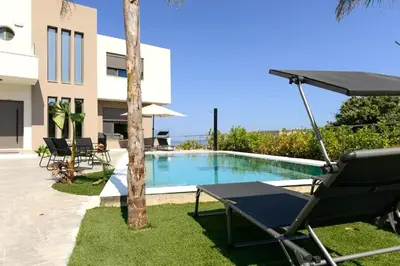 a villa with a pool and a table and a chair at Aetheria Luxury Villa in Kalithies