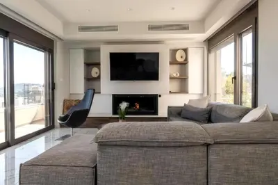 a living room with a couch and a television at Aetheria Luxury Villa in Kalithies