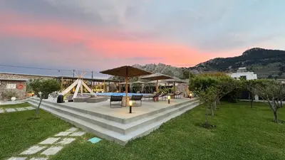 a patio with tables and umbrellas in a yard at LA Casa Di Lusso Casa N2 Adults Only in Kolimbia