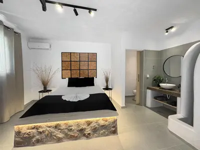 a bedroom with a large bed and a bathroom at LA Casa Di Lusso Casa N2 Adults Only in Kolimbia