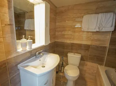 a bathroom with a sink and a toilet and a mirror at Marieta Suite in Vrachonisída touArchangélou