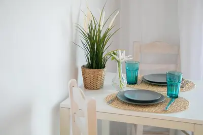 a table with two plates and blue glasses on it at Marieta Suite in Vrachonisída touArchangélou