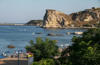 a beach with umbrellas and people on the beach at Marieta Suite in Vrachonisída touArchangélou