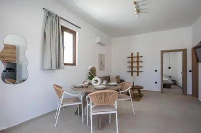 a dining room with a table and chairs at Zaia Suites & Living, Suite N3, pool view, central in Gennadi