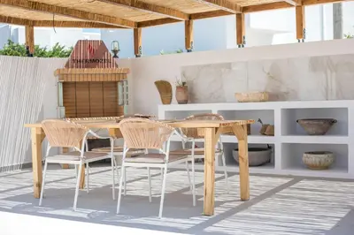 a dining room with a wooden table and chairs at Zaia Suites & Living, Suite N3, pool view, central in Gennadi
