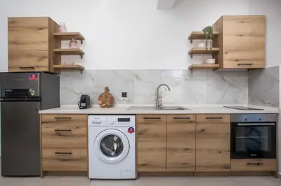 a kitchen with a washing machine and a sink at Zaia Suites & Living, Suite N3, pool view, central in Gennadi