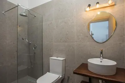 a bathroom with a toilet and a sink and a mirror at Zaia Suites & Living, Suite N3, pool view, central in Gennadi