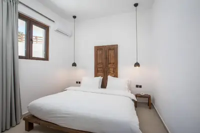a bedroom with a white bed and a window at Zaia Suites & Living, Suite N3, pool view, central in Gennadi