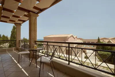a patio with chairs and a table on a balcony at Lindian Dream Seaside Resort- Adults Only in Líndos