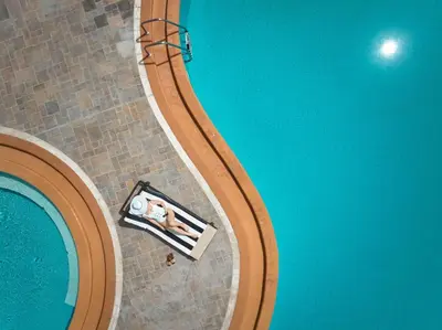 an overhead view of a pool with two people sitting in a pool at Lindian Dream Seaside Resort- Adults Only in Líndos