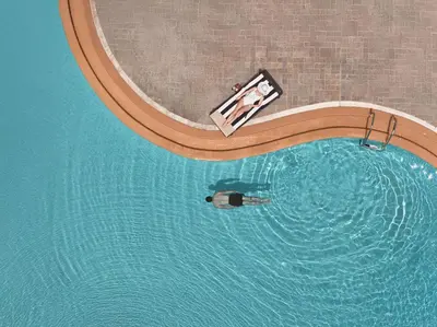 an overhead view of a swimming pool with a person in a boat at Lindian Dream Seaside Resort- Adults Only in Líndos