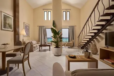 a living room with a staircase and a living room at Lindian Dream Seaside Resort- Adults Only in Líndos