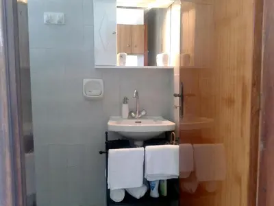 a bathroom with a sink and white towels at Merryland Studios & Apartments in Kremasti