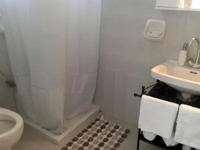a bathroom with a shower and a toilet and a sink at Merryland Studios & Apartments in Kremasti