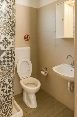 a bathroom with a toilet and a sink at Merryland Studios & Apartments in Kremasti