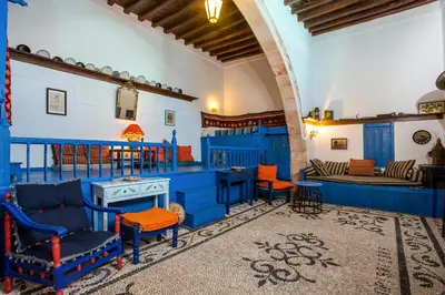 a living room with blue furniture and orange chairs at Al 583 di Lindos in Líndos
