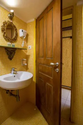 a bathroom with a sink and a wooden door at Al 583 di Lindos in Líndos