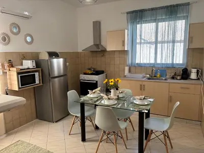 a kitchen with a table with chairs and a refrigerator at V&G Cozy Home, Pilona Village in vlicha