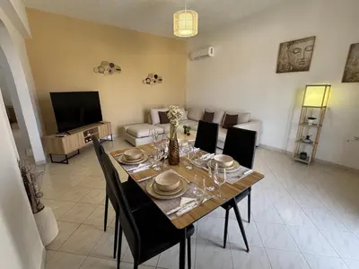 a dining room with a table with chairs and a television at V&G Cozy Home, Pilona Village in vlicha