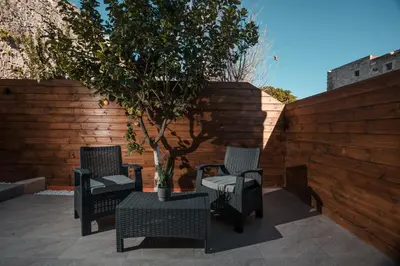 two chairs and a table with a tree on a patio at Villa il Borgο in Rhodes Town