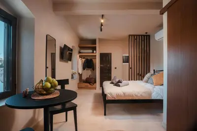 a bedroom with a bed and a table with a bowl of fruit at Villa il Borgο in Rhodes Town
