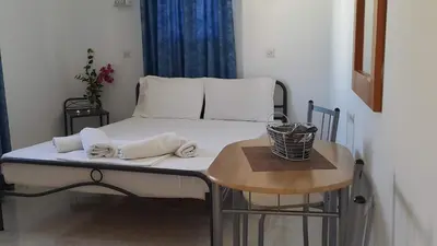 a bed in a room with a small table at Lindos Center Studios in Líndos