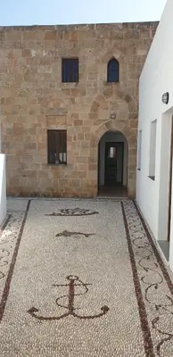 a building with a tile floor in front of a building at Lindos Center Studios in Líndos
