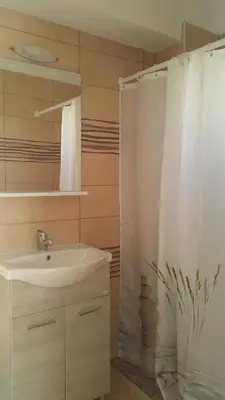 a bathroom with a sink and a shower curtain at Lindos Center Studios in Líndos