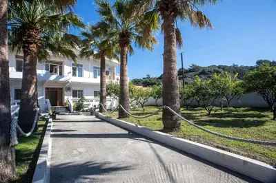 a street with palm trees and a building at Malibu Villa in Kremasti